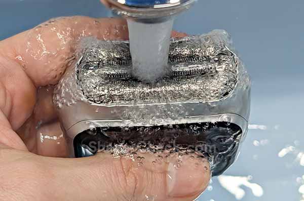 Rinsing the soap with tap water.